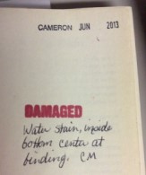 Red "Damaged" stamp with hand-written description of damage