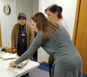 Martha, Sarah and Katie perusing the scrapbook