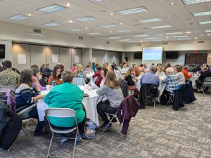 70 library workers sitting at round tables