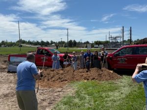a pile of dirt with a line of people with shovels