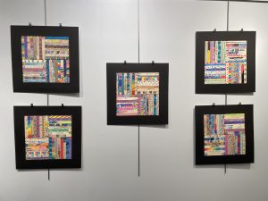 five framed squares made up of 32 individually decorated craft sticks, arranged to look like a quilt block