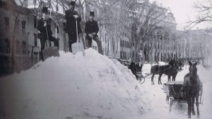 Huge pile of snow and men with suits and shovels