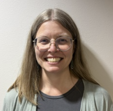 Straight shoulder-length hair, glasses, smiling