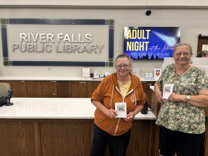 two ladies with their passports in the River Falls library.